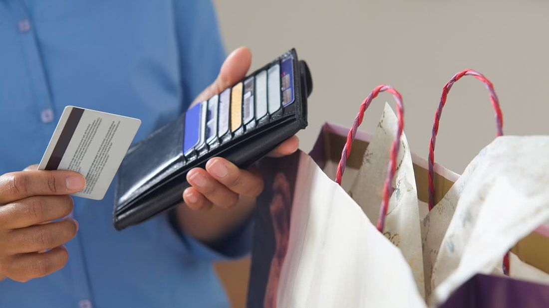 Man with wallet wondering how many credit cards he needs