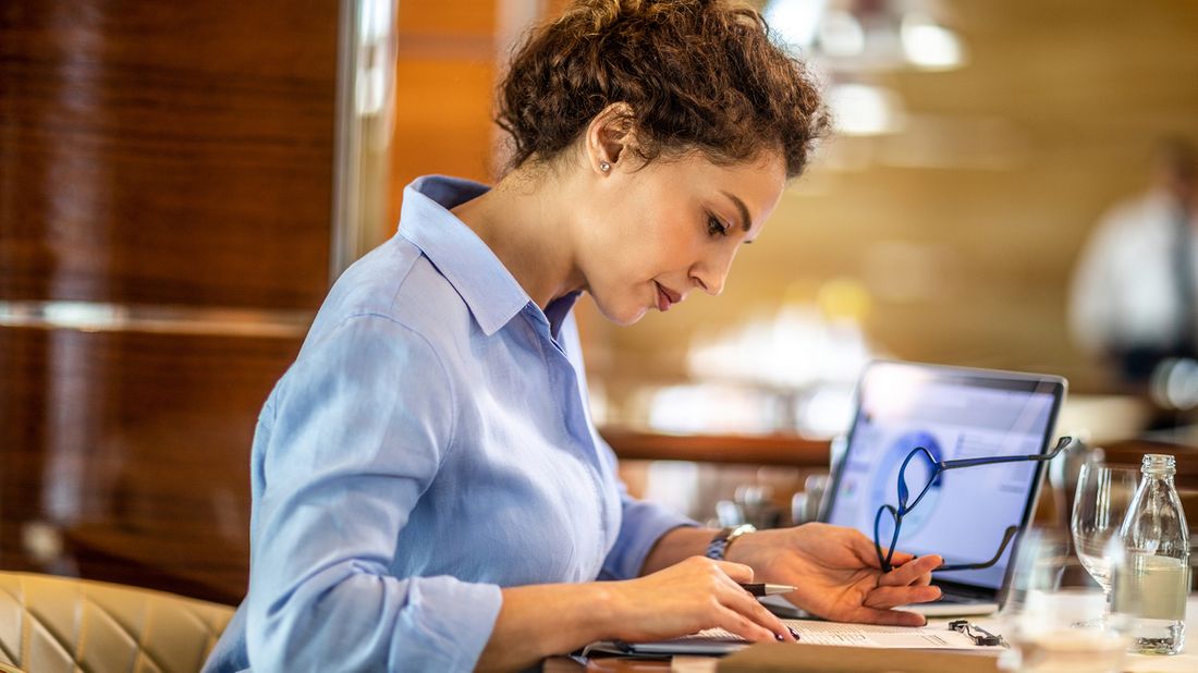 female business owner calculating expenses at desk