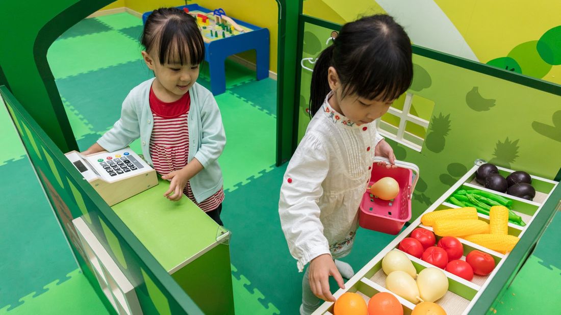 Two young girls play store together at school