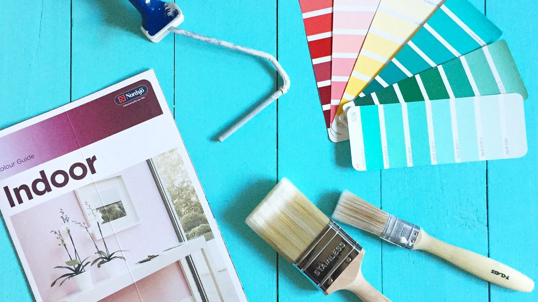 Indoor colour guide, paint brushes, and paint swatches for home renovation