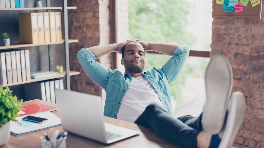 Man relaxed with his feet on a desk.