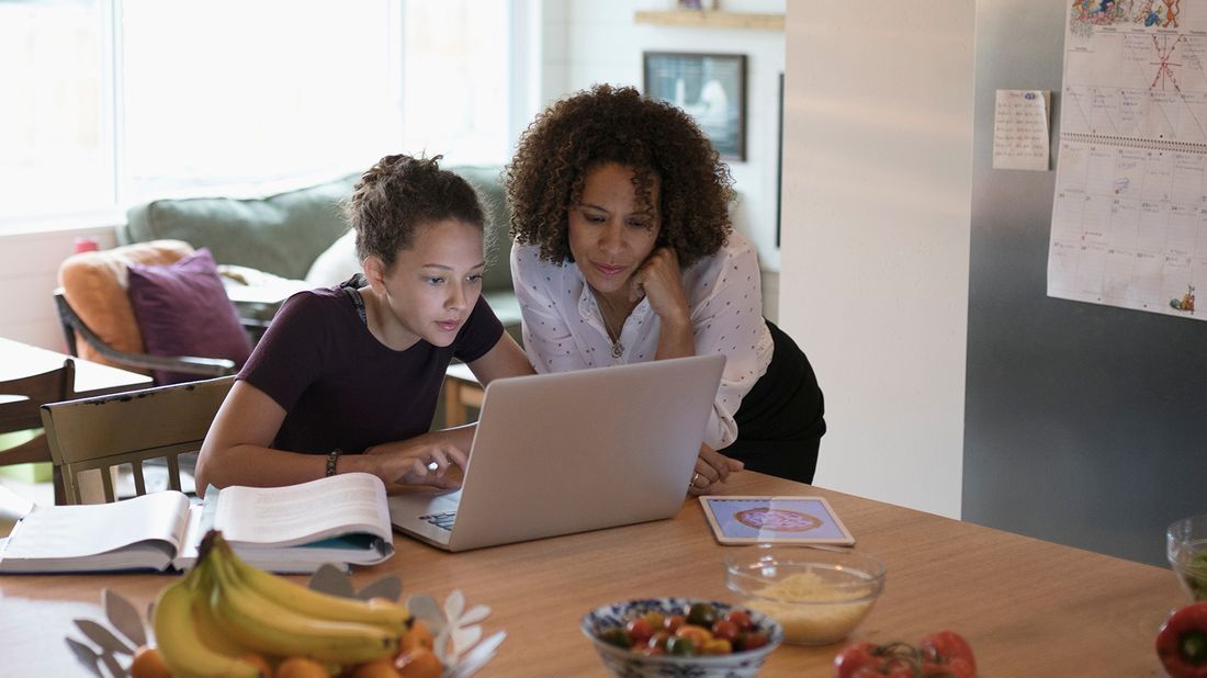 mom and daughter working on FAFSA in kitchen