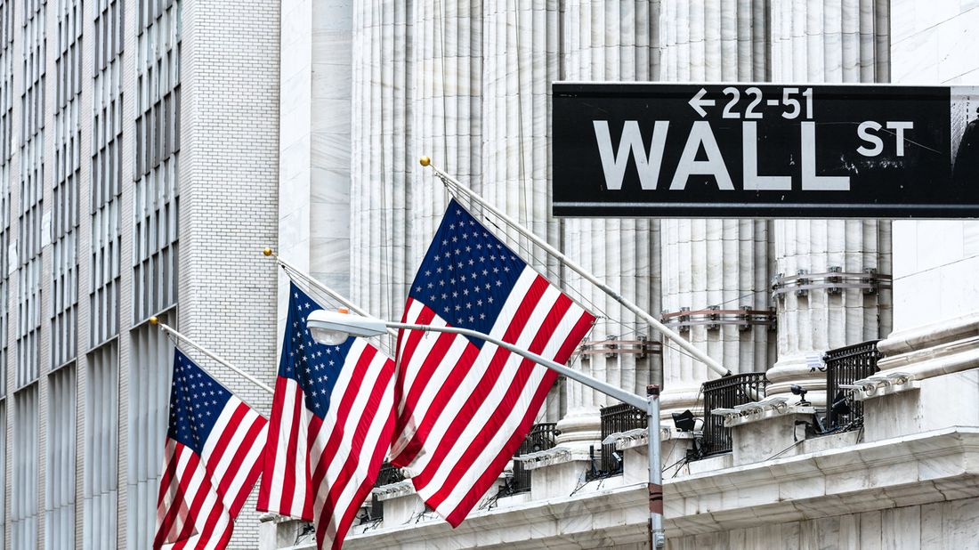 New York Stock Exchange with American flags and Wall Street sign