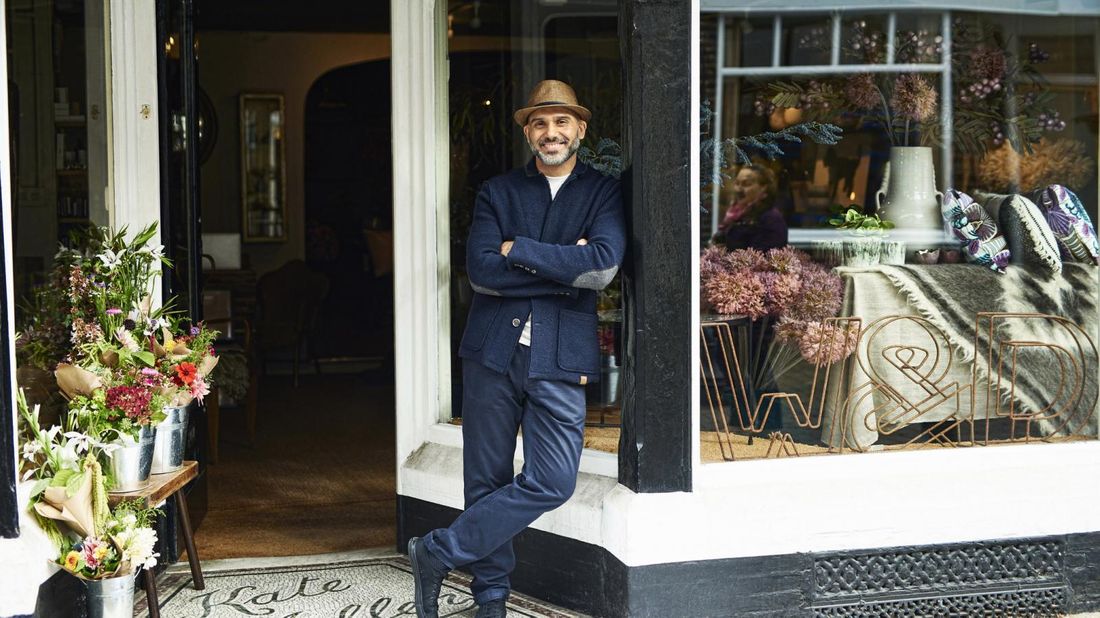 Man standing int front of his furniture store. 