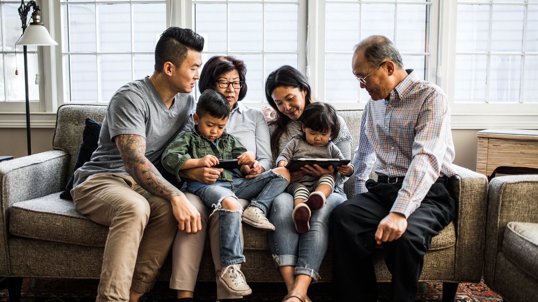 Three generations of a family sitting on a couch.