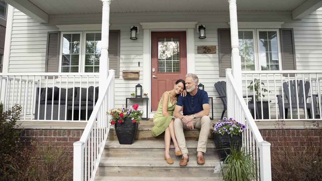 Couple sitting on front porch steps.