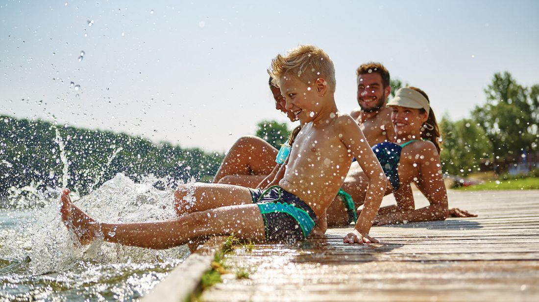 Family on the dock at a lake.