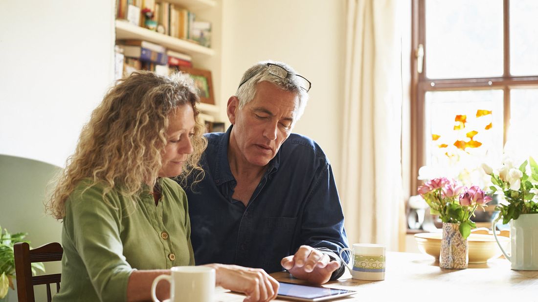 Couple looking at tablet and discussing the high cost of health care in retirement.