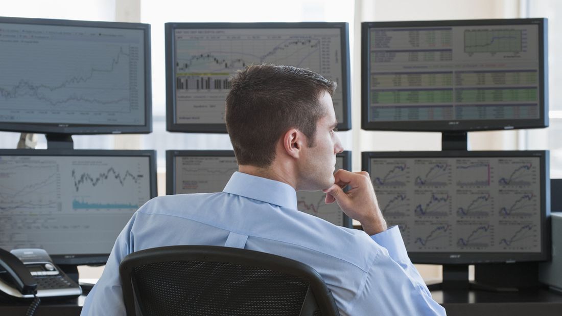 A man watching stock trading action on computer screens