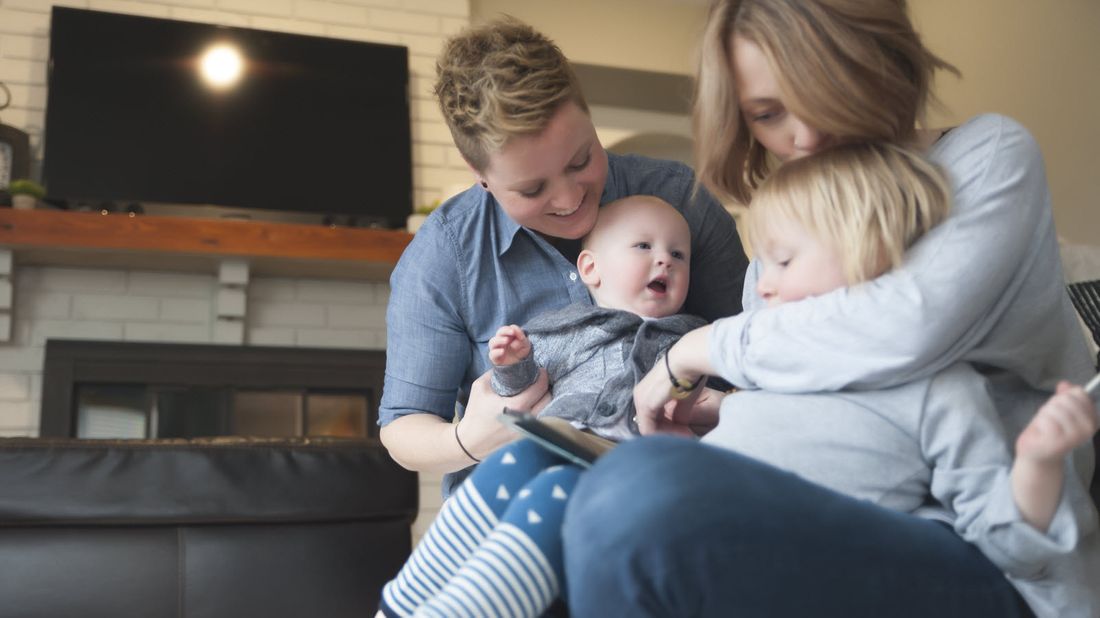 Lesbian couple playing with their children.