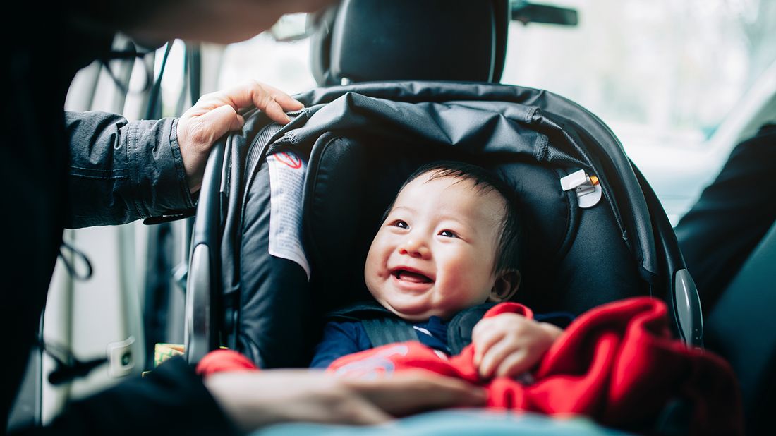 baby being strapped into car seat 