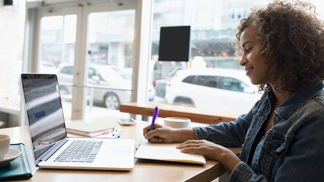 self-employed woman working on laptop researching benefits