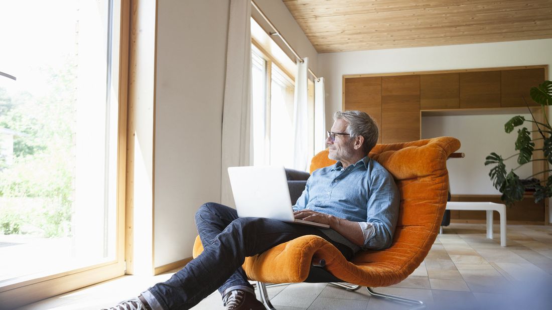 A man on his laptop studying how an annuity protects from the uncertainty of stocks