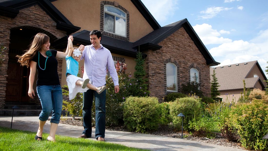 Family in front of home planning to refinance their mortgage. 