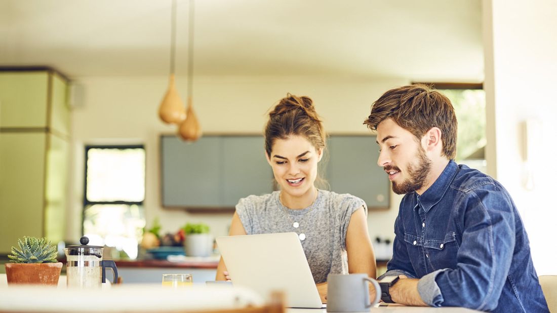 A young couple reading a secure act summary on laptop