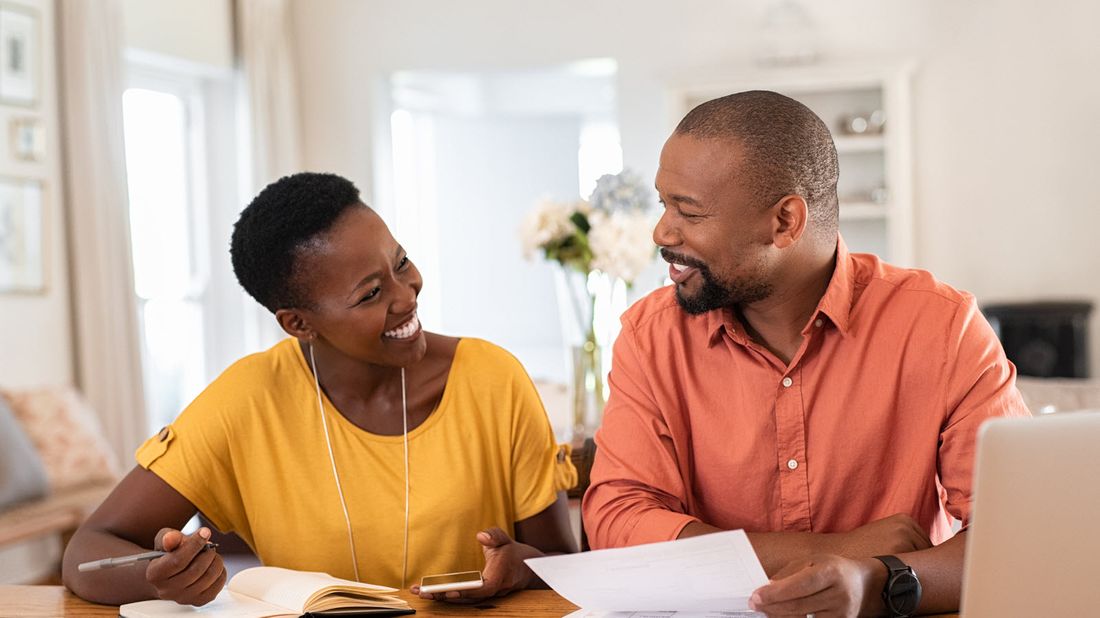 A couple discusses guaranteed universal life insurance at the dinner table