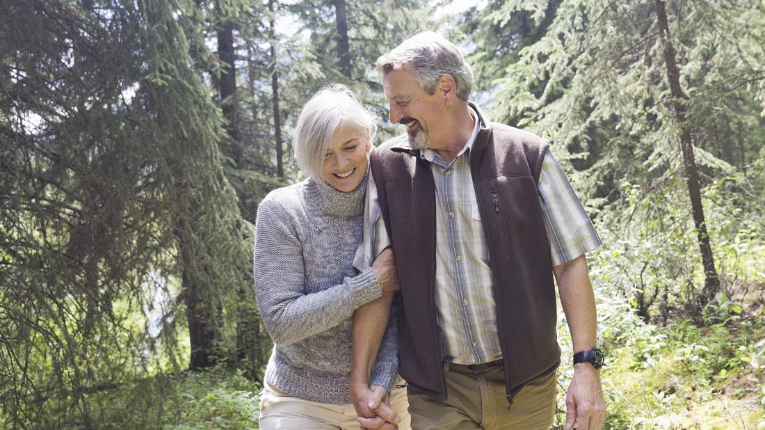 Couple walking in the forest discussing how to start planning for retirement.