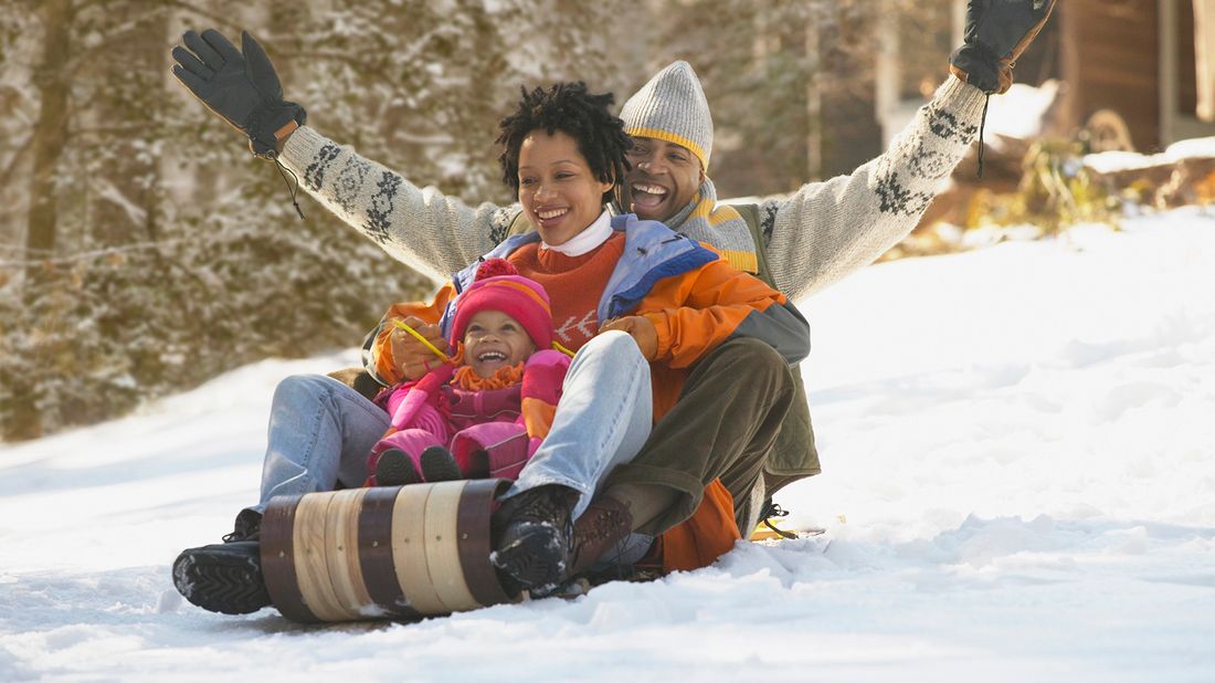 Family sledding together on a winter getaway.