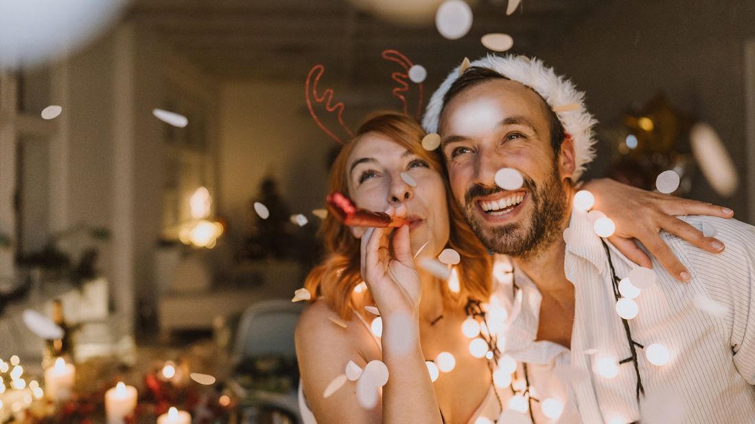 Couple celebrating New Year’s together with lights hoping to achieve money resolutions. 