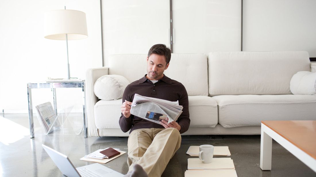 man reading a newspaper researching investing in ipos