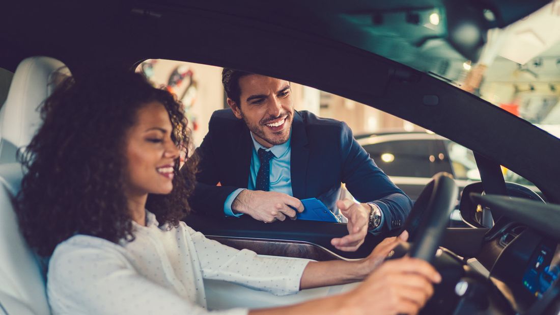 a young woman car shopping and considering a 7-year auto loan