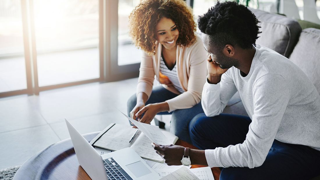 couple working on finances together to get started on their financial resolutions.