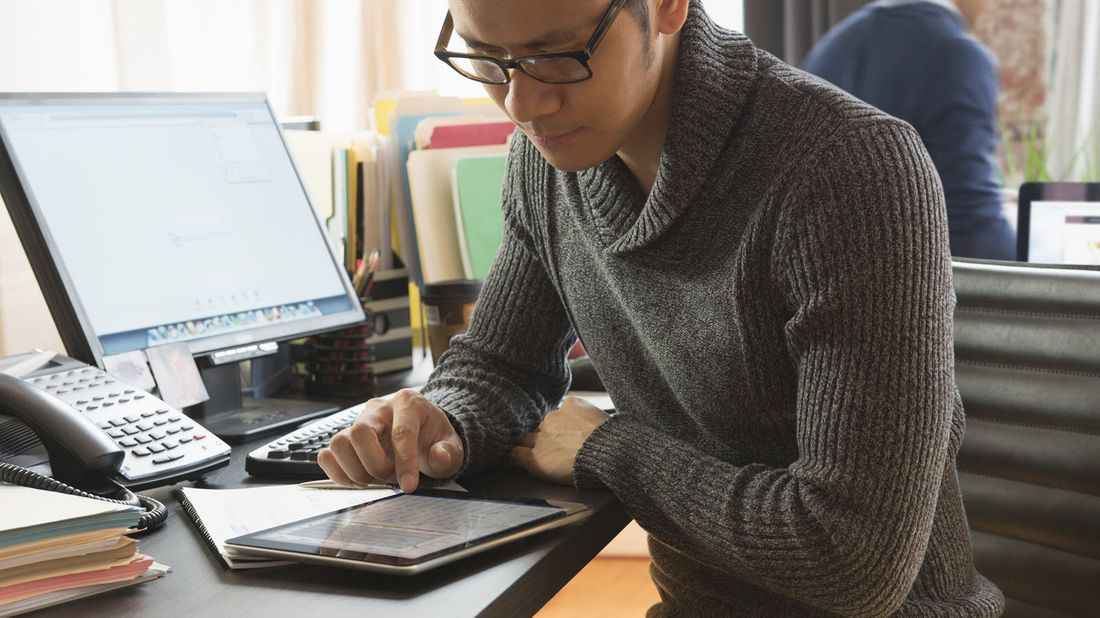 Man looking at tablet researching the difference between group disability insurance and individual disability insurance.