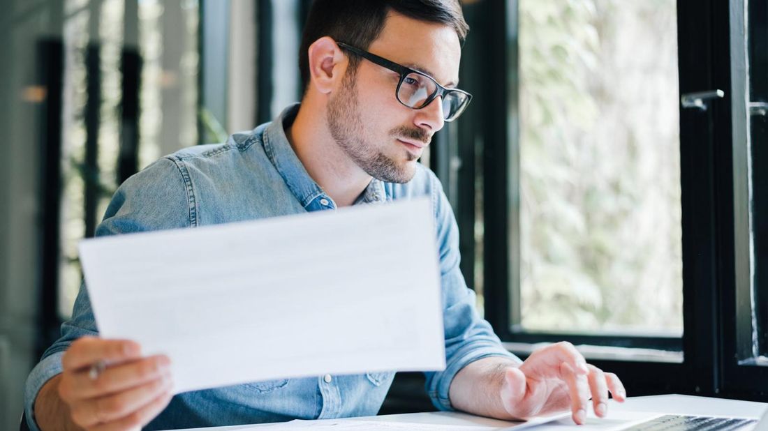 Man at desk researching the advantages and disadvantages of group disability insurance.