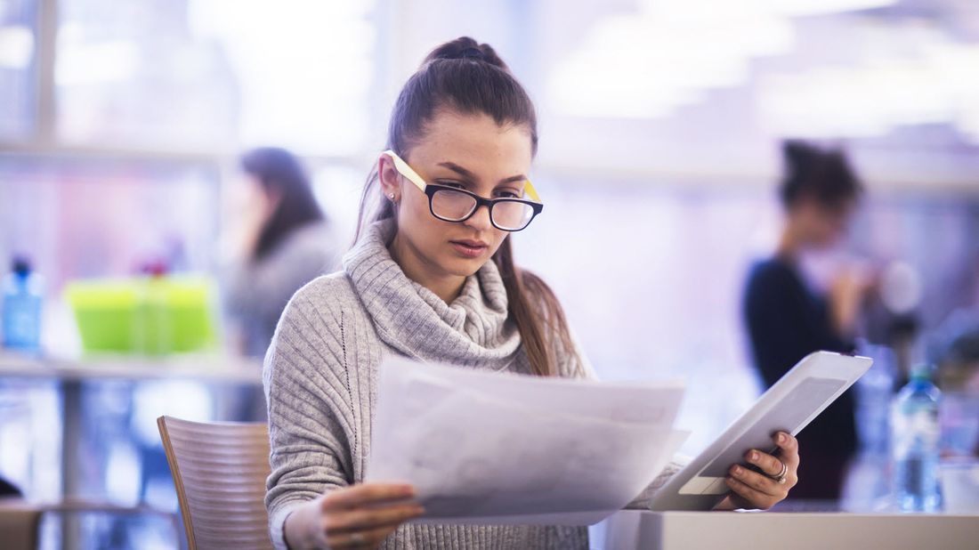 Woman looking at papers trying to determine the difference between an FSA vs. an HSA.