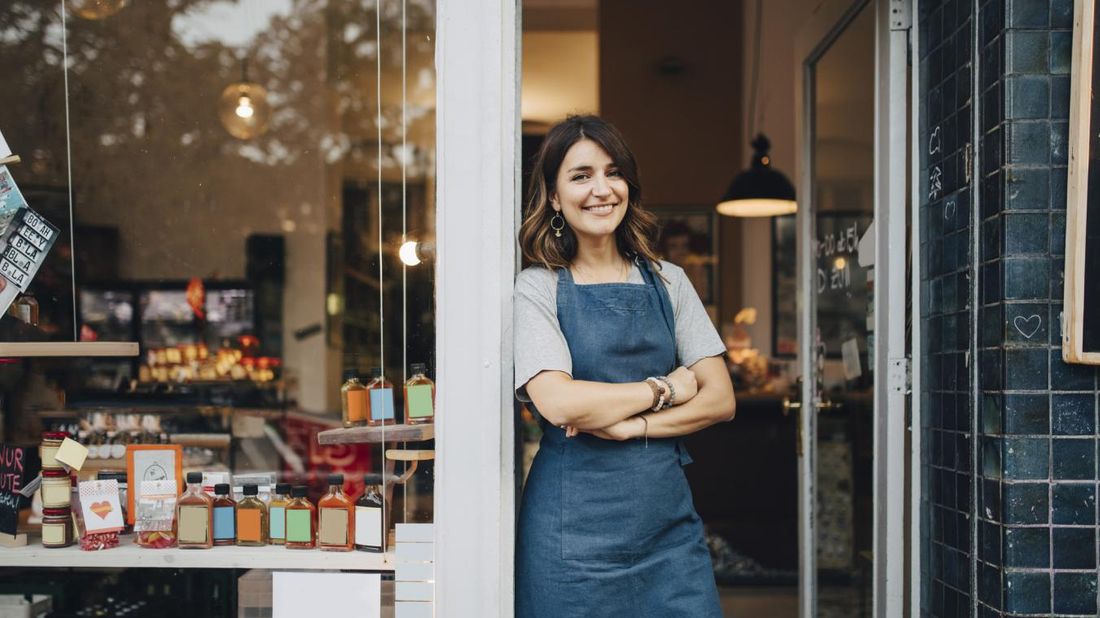 Female owner at deli entrance building business plan