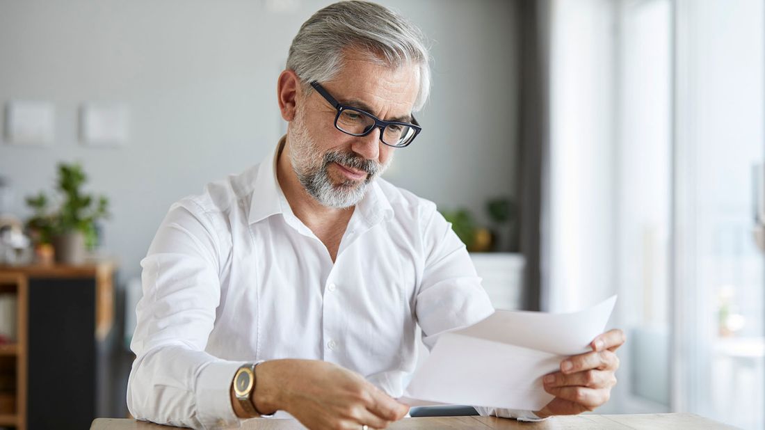 man reading letter at home