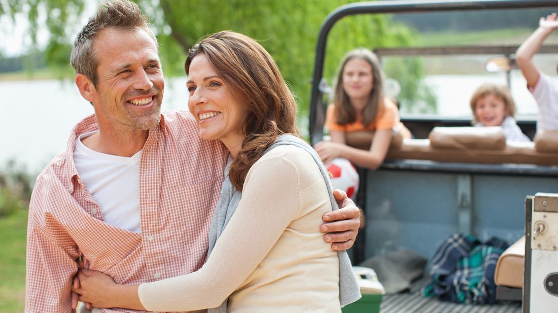 Couple and their children at a lake.