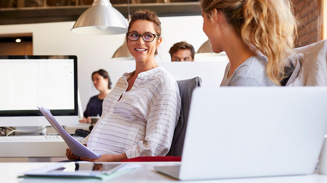 Pregnant businesswoman holding documents in office