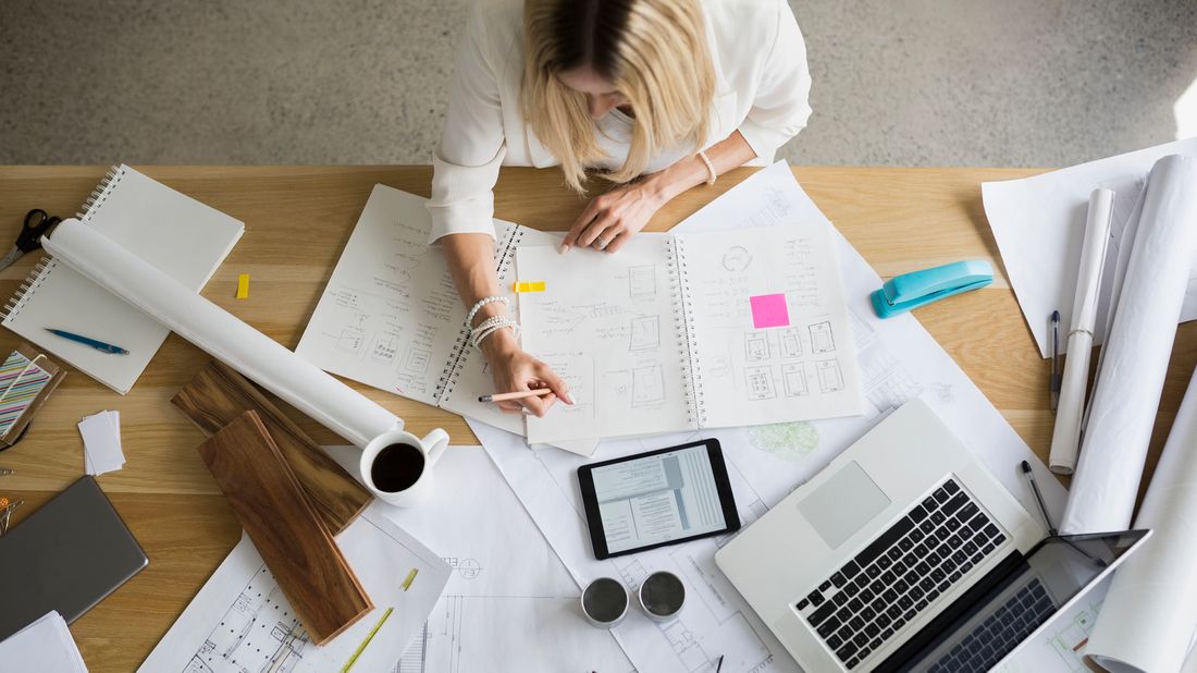 Woman at desk weighing the pros and cons of getting a bonus or a raise