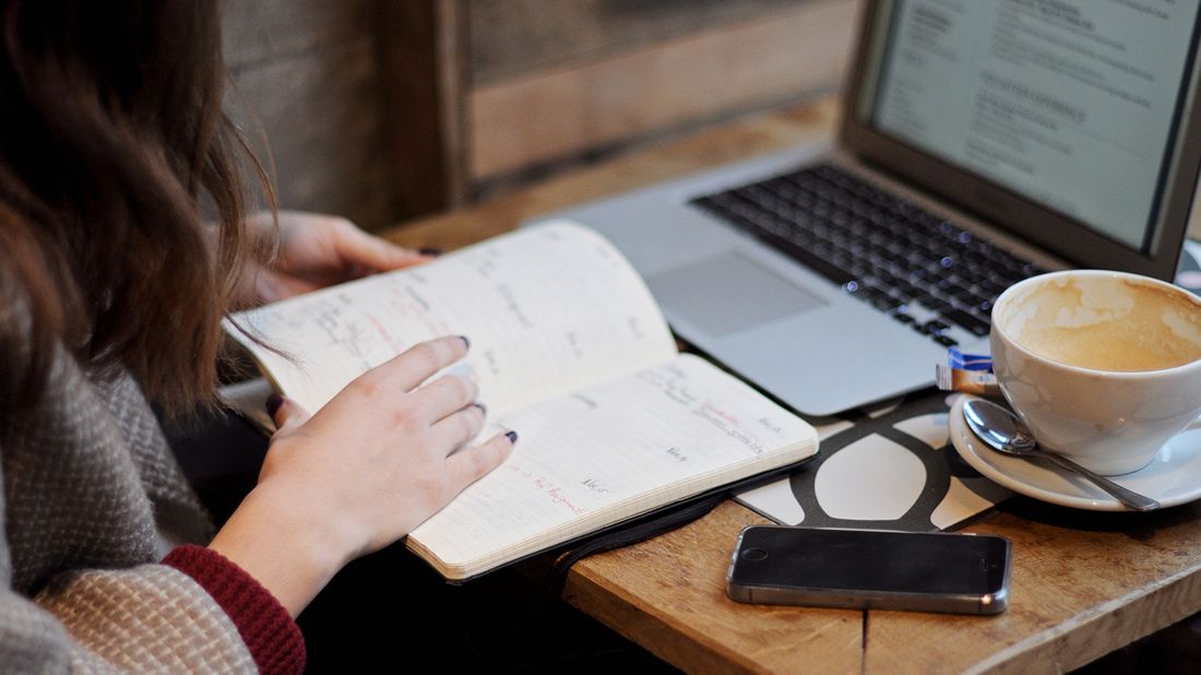 woman organizing and drinking coffee