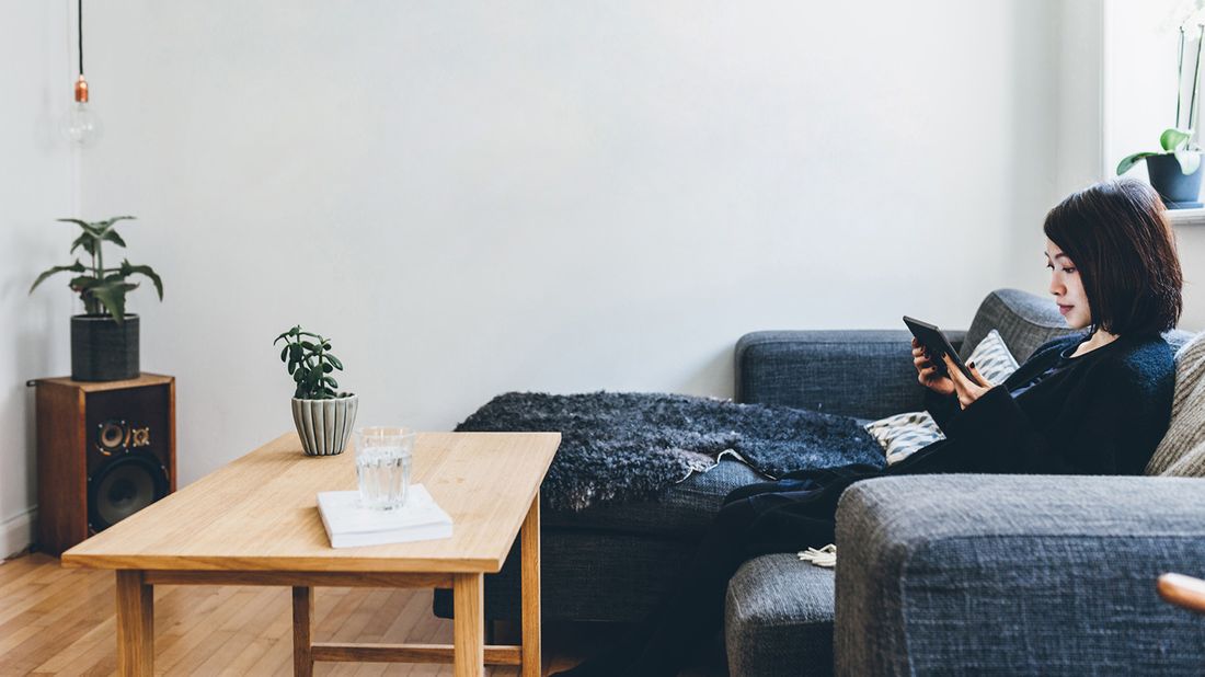 woman sitting on couch with blanket