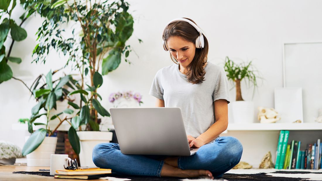 woman wearing headphones working on laptop 