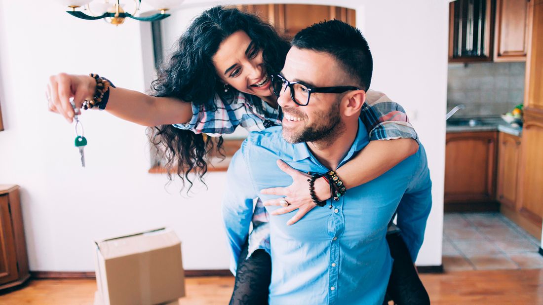 Young couple with keys to new home.