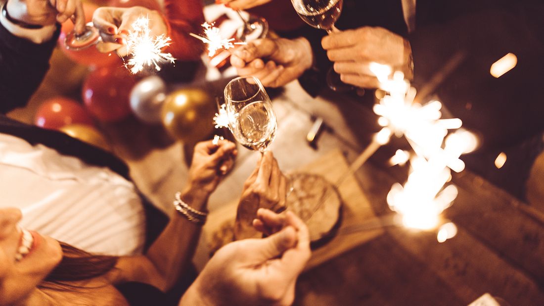 Friends celebrating with champagne and sparklers. 