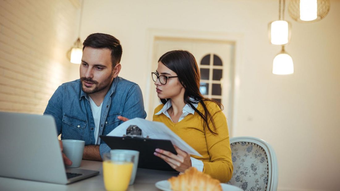 Couple doing finances at the breakfast table.