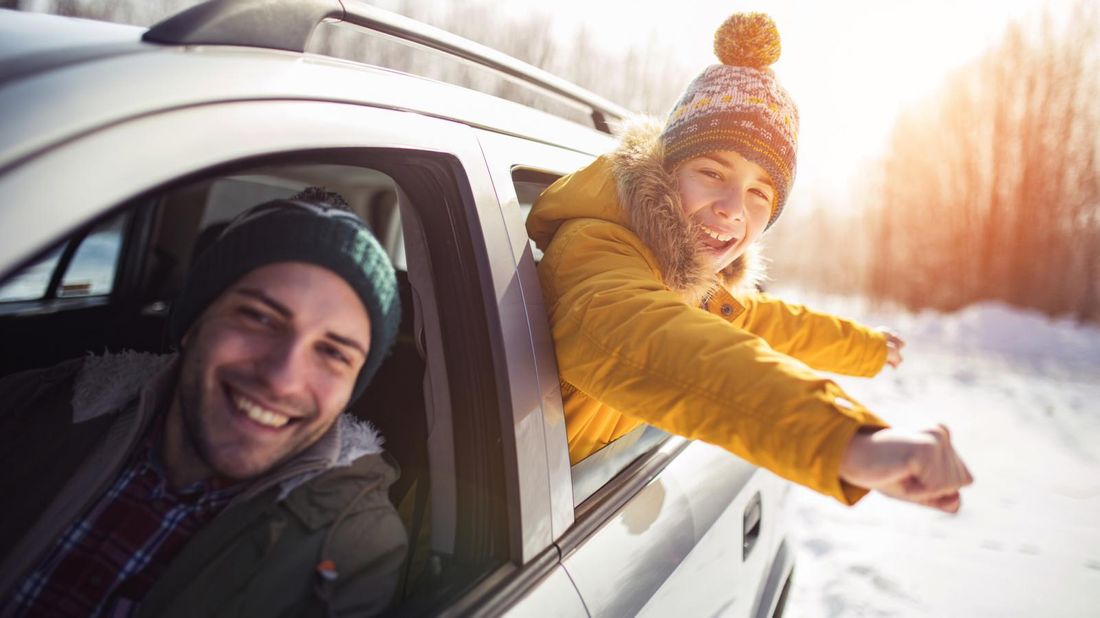 Father and son riding in car in winter