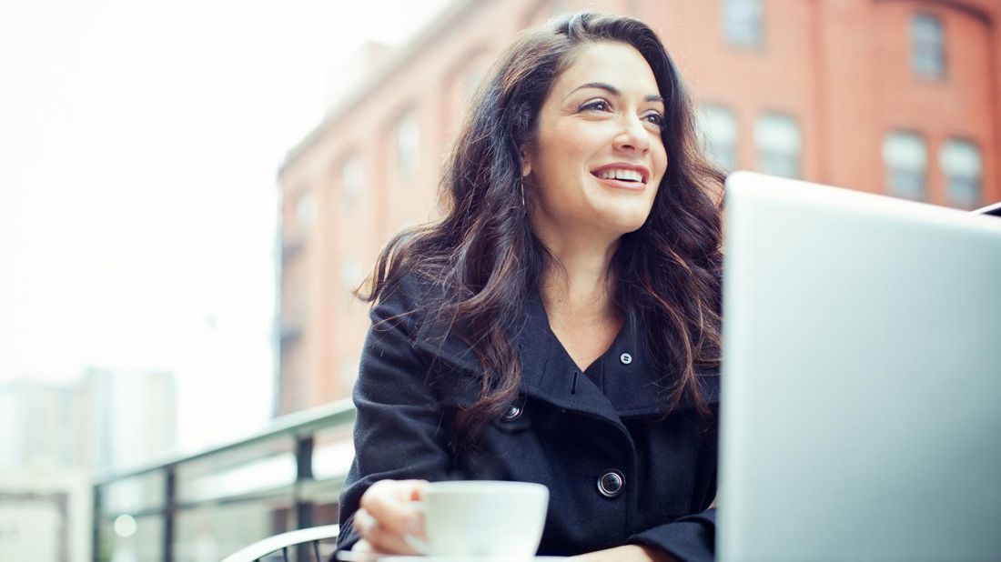 Woman at cafe with laptop.