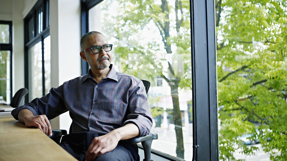 Man sitting at desk and looking out a window