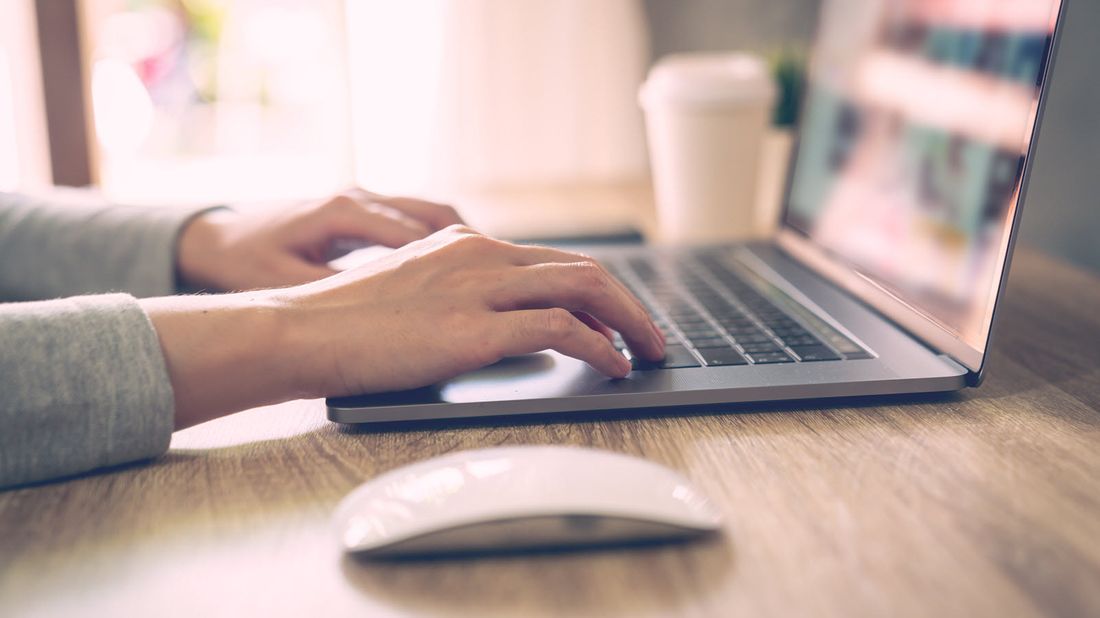 Woman looking at computer and reading Northwestern Mutual Market Commentary