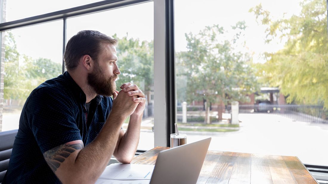 Man reading Northwestern Mutual Market Commentary on a laptop