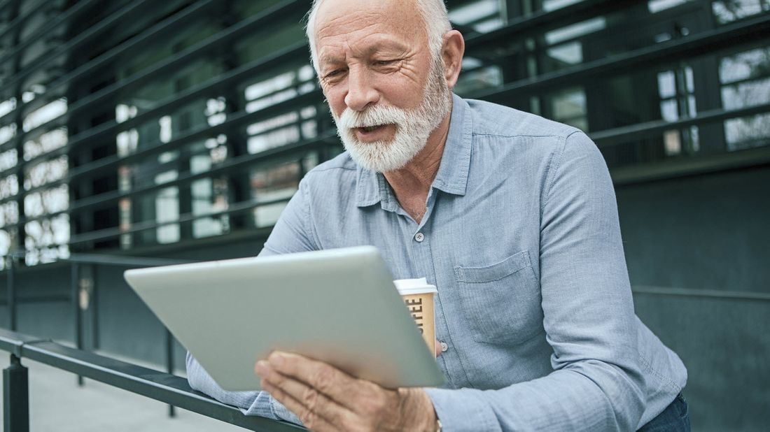 Man drinking coffee and reading Northwestern Mutual Market Commentary