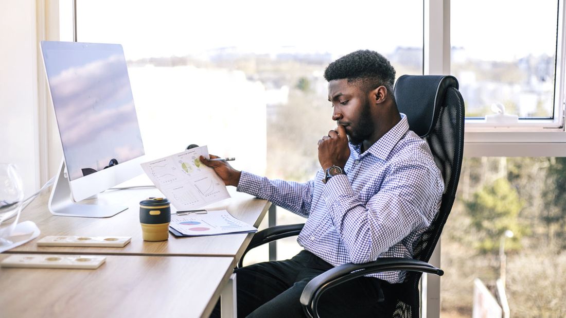 Man at desk reading Northwestern Mutual Market Commentary.