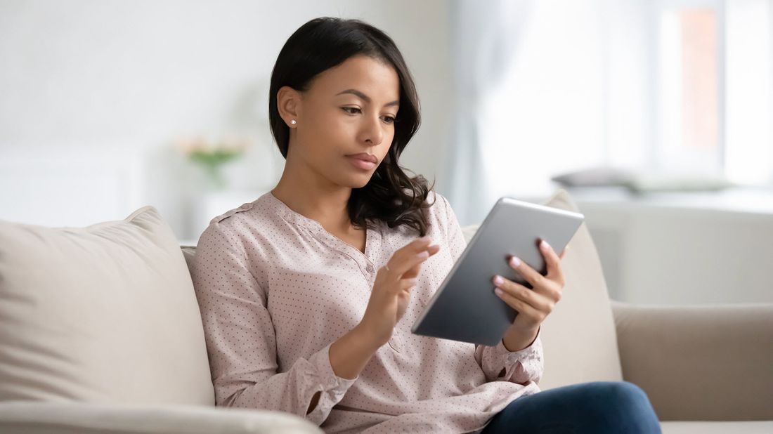 Woman reading news on a tablet.