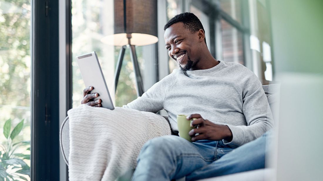 Man drinking coffee and reading Northwestern Mutual Market Commentary