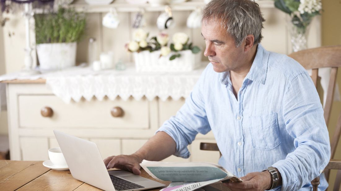 Man sitting at table reading Northwestern Mutual Market Commentary